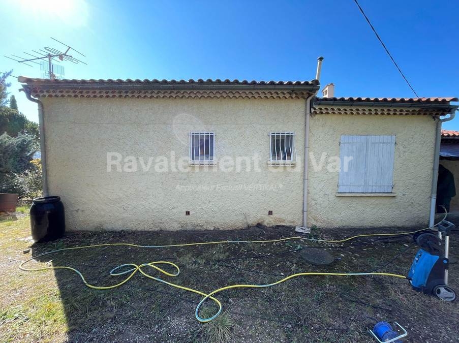 Maison en cours de ravalement avec tuyaux et équipements.
