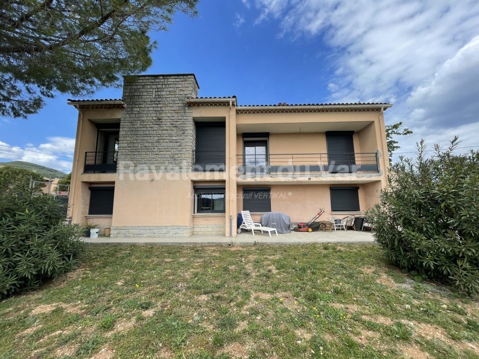 Maison de deux étages avec balcon et jardin.